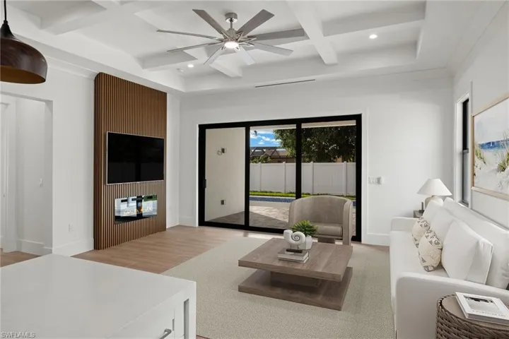 Living room with beamed ceiling, ceiling fan, coffered ceiling, and light hardwood / wood-style flooring