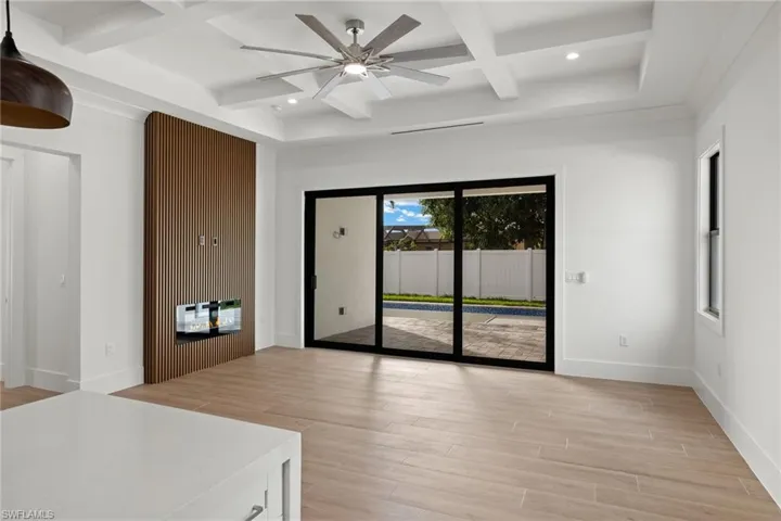 Spare room with ceiling fan, light hardwood / wood-style floors, beam ceiling, and coffered ceiling