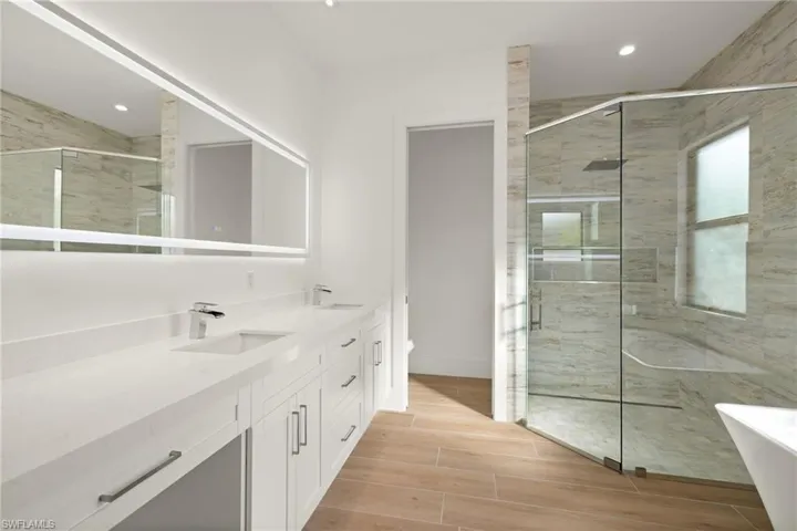 Bathroom featuring vanity, toilet, and a shower with shower door