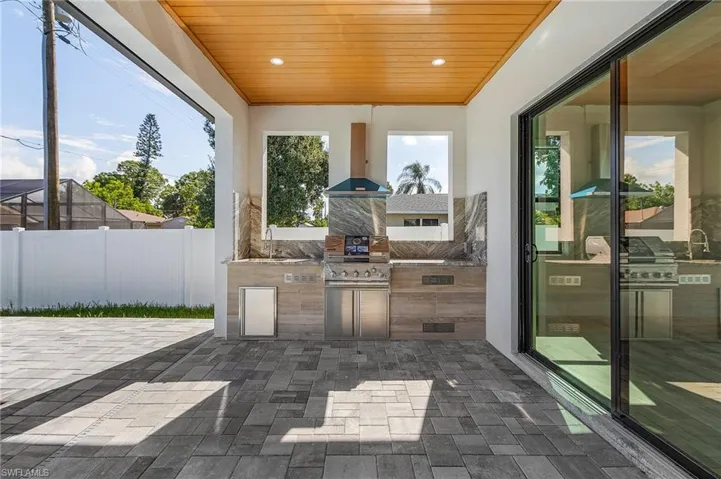 View of patio with sink, area for grilling, and exterior kitchen