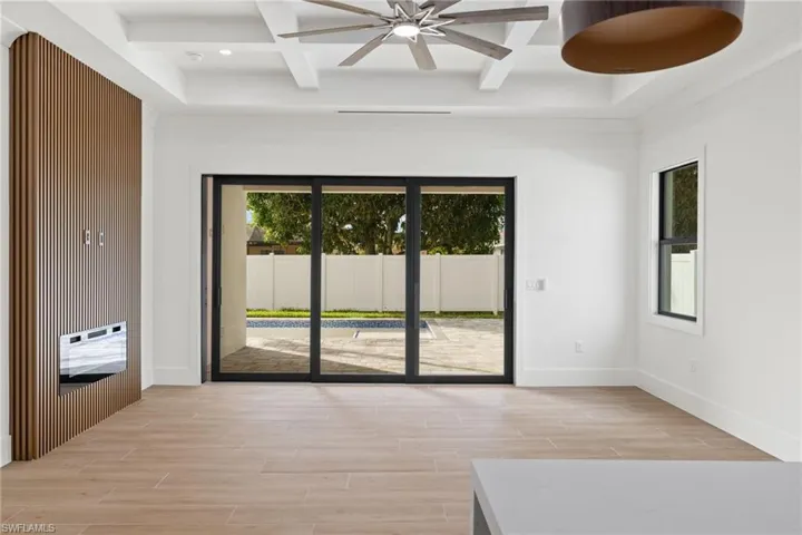 Empty room featuring ceiling fan, beamed ceiling, light hardwood / wood-style floors, and coffered ceiling