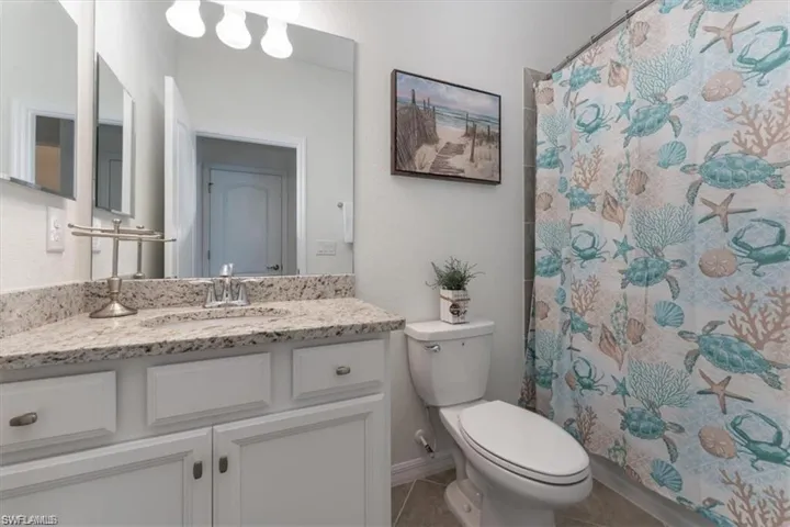 Full bathroom with vanity, tile patterned flooring, and curtained shower