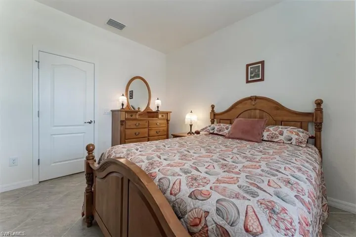 Bedroom with baseboards and light tile patterned floors