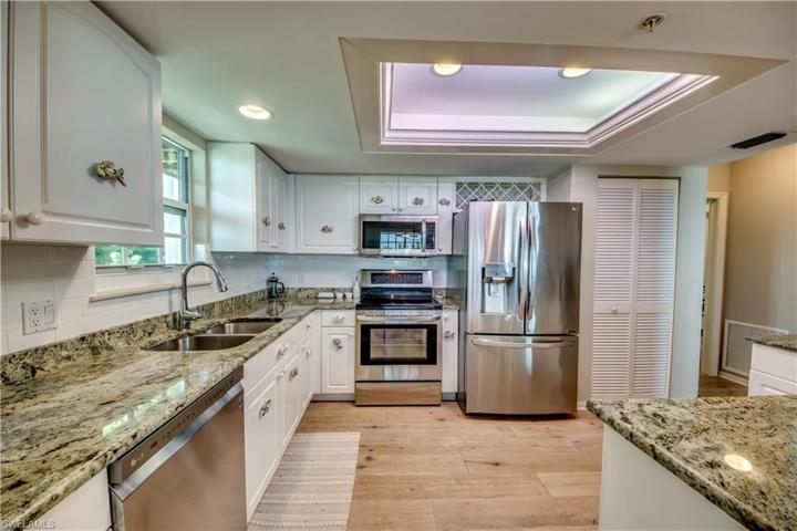 Kitchen with granite countertops, white cabinets, SS appliances and tray ceiling