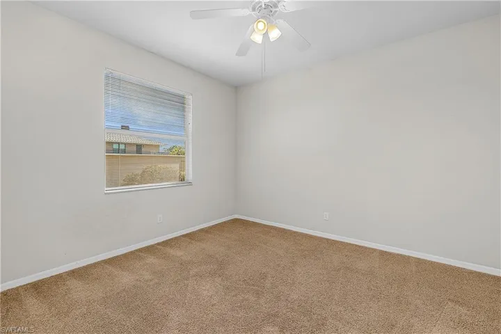 Spare room featuring carpet flooring and ceiling fan