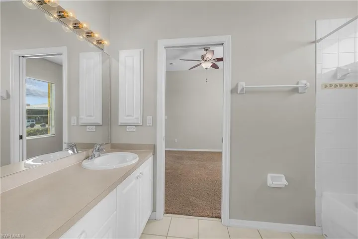Jack & Jill Bathroom featuring vanity, light tile patterned floors, shower / bath combination.