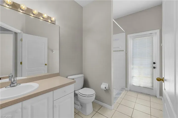 Full pool bath with a shower, vanity, and light tile patterned floors