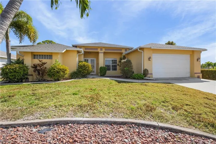 View of front of home featuring stucco siding, a front lawn, concrete driveway, and a garage