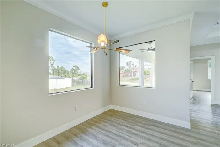 Unfurnished dining area featuring crown molding, light wood-type flooring, and a chandelier