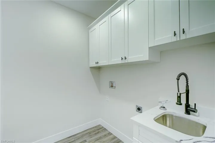 Laundry room featuring cabinet space, electric dryer hookup, light wood-style floors, and hookup for a washing machine