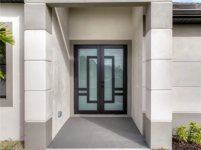 Doorway to property featuring french doors and stucco siding