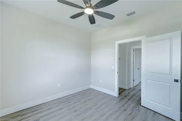 Unfurnished room with light wood-type flooring and a ceiling fan