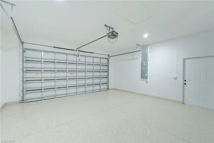 Garage featuring electric panel and a garage door opener