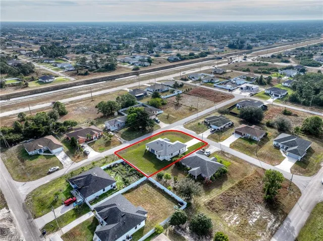 Aerial view of property and surrounding area with nearby suburban area and property parcel outlined