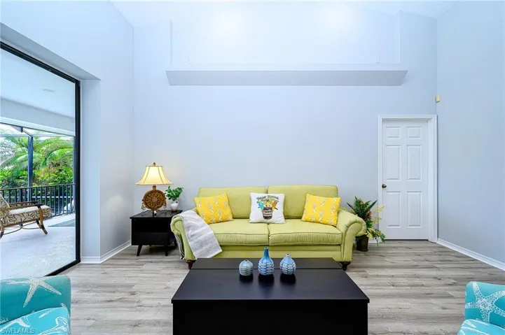 Living room featuring high vaulted ceiling and light wood-type flooring