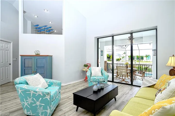 Living room featuring ceiling fan, light hardwood / wood-style flooring, and high vaulted ceiling