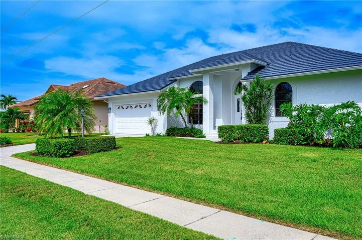 Single story home with a garage and a front yard