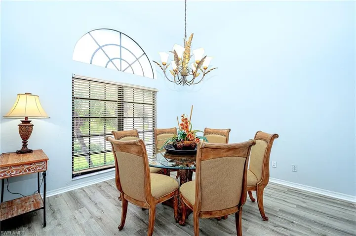 Dining area with a notable chandelier and light hardwood / wood-style flooring