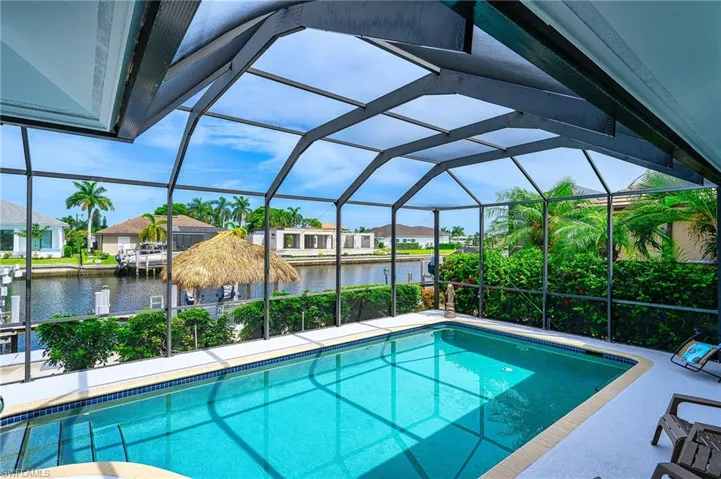 View of pool with a water view and a lanai