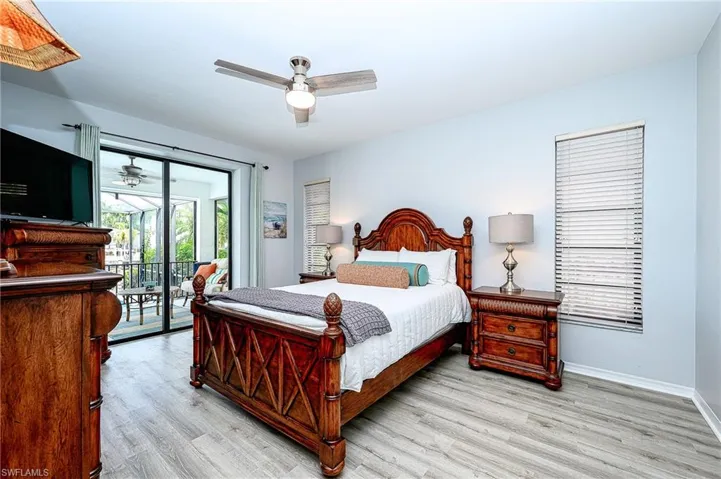 Bedroom with access to exterior, light wood-type flooring, and ceiling fan