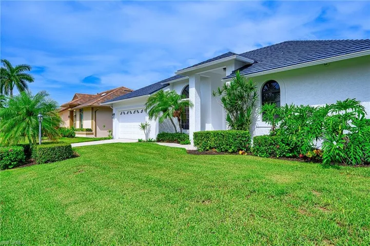 View of front of house with a garage and a front yard