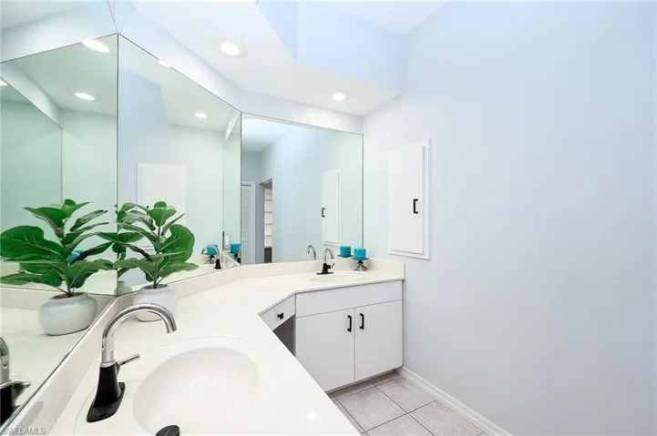 Bathroom featuring tile patterned floors and double sink vanity