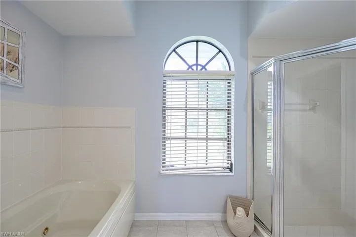 Bathroom featuring independent shower and bath and tile patterned flooring