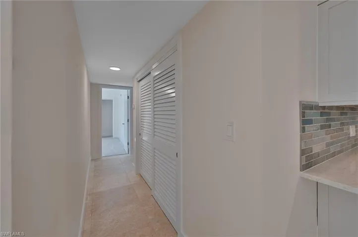 Hallway featuring recessed lighting, baseboards, and light tile patterned floors