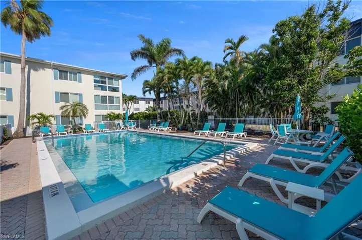Community pool featuring a patio area and fence