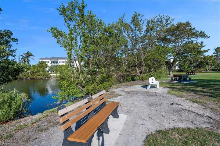 View of property's community featuring a patio area, a yard, and a water view