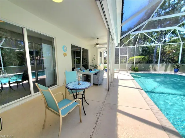View of swimming pool featuring a lanai, a patio area, and ceiling fan