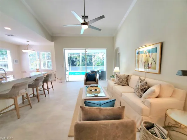 Tiled living room featuring crown molding, high vaulted ceiling, and ceiling fan