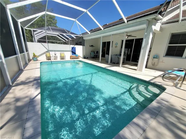 View of swimming pool with a patio area, a lanai, and ceiling fan