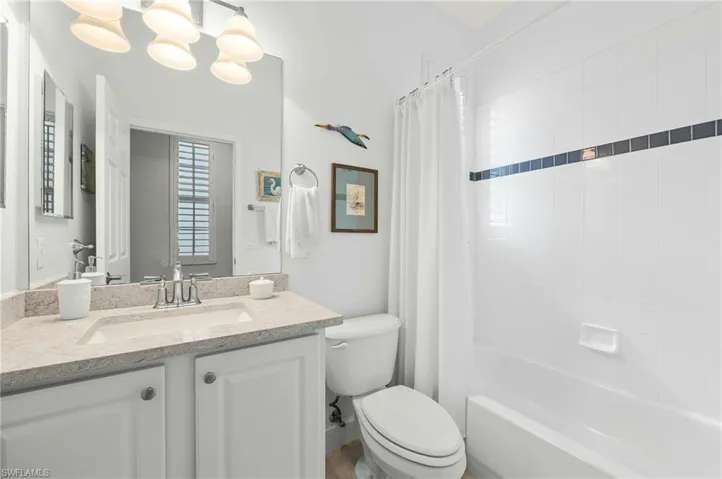 Full bathroom featuring shower / bath combo with shower curtain, vanity, and toilet