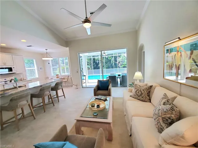 Living room with a healthy amount of sunlight, sink, ornamental molding, and ceiling fan