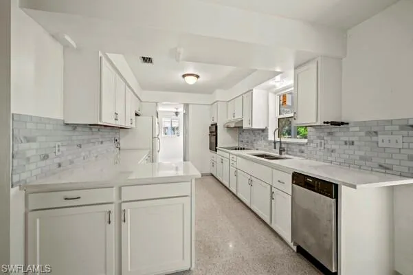 Kitchen with sink, white cabinetry, tasteful backsplash, and black appliances