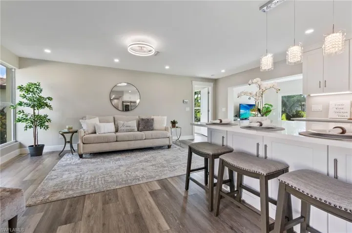 Living room with a healthy amount of sunlight and dark wood-type flooring