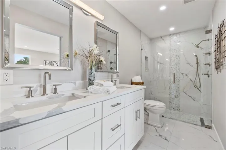 Bathroom with vanity, toilet, and a shower with shower door