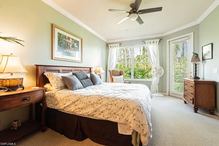 Carpeted bedroom featuring crown molding and ceiling fan