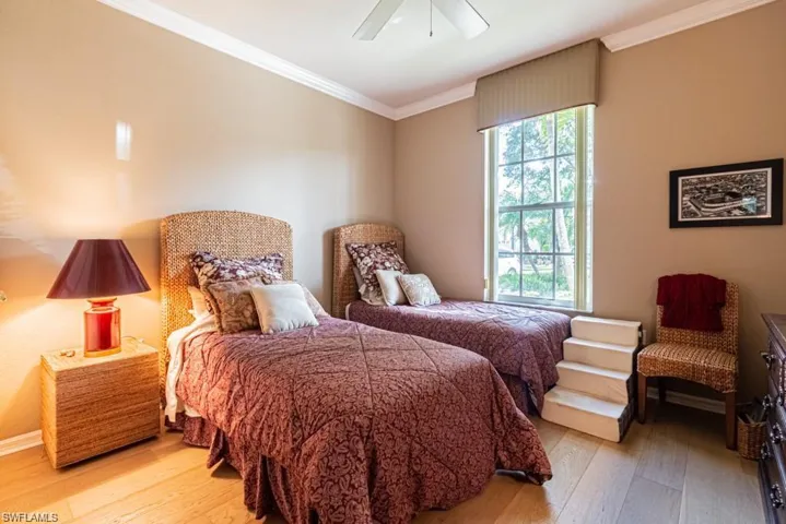 Bedroom featuring light hardwood / wood-style floors, ceiling fan, and crown molding
