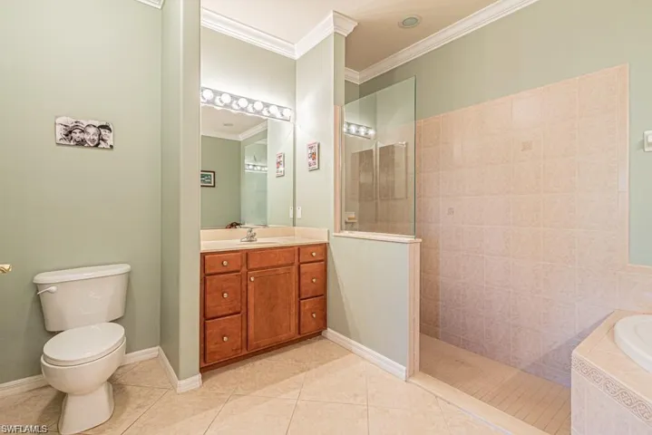 Full bathroom with ornamental molding, vanity, separate shower and tub, tile patterned flooring, and toilet