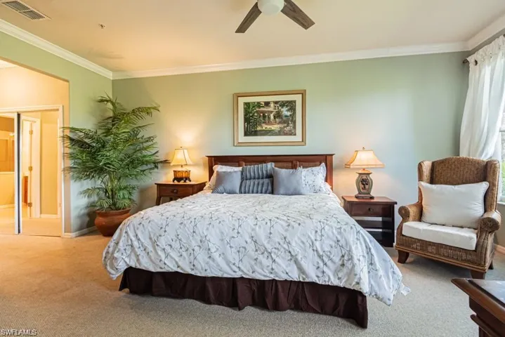 Bedroom with carpet flooring, ceiling fan, and crown molding