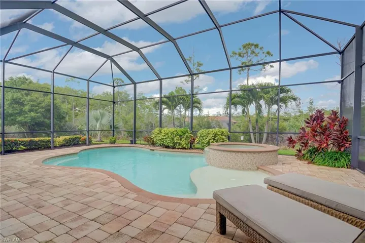 View of pool with a patio, a lanai, and a pool with connected hot tub