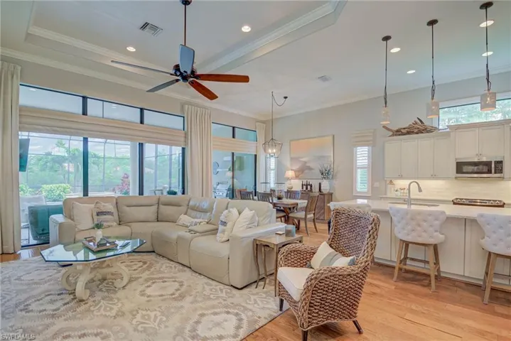 Living area with light wood finished floors, a ceiling fan, ornamental molding, and recessed lighting