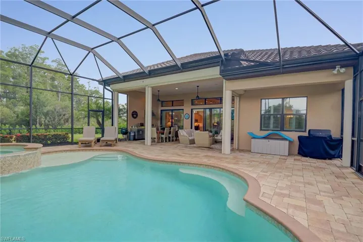 View of swimming pool with an outdoor living space, a patio area, a ceiling fan, a pool with connected hot tub, and glass enclosure