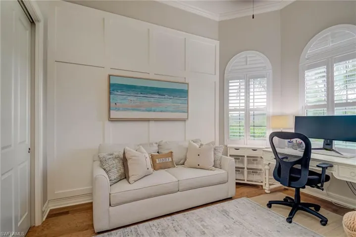 Office space with crown molding and light wood-type flooring