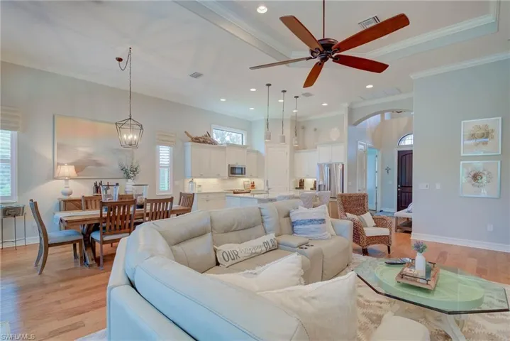 Living room featuring light wood-style flooring, ceiling fan, ornamental molding, and recessed lighting