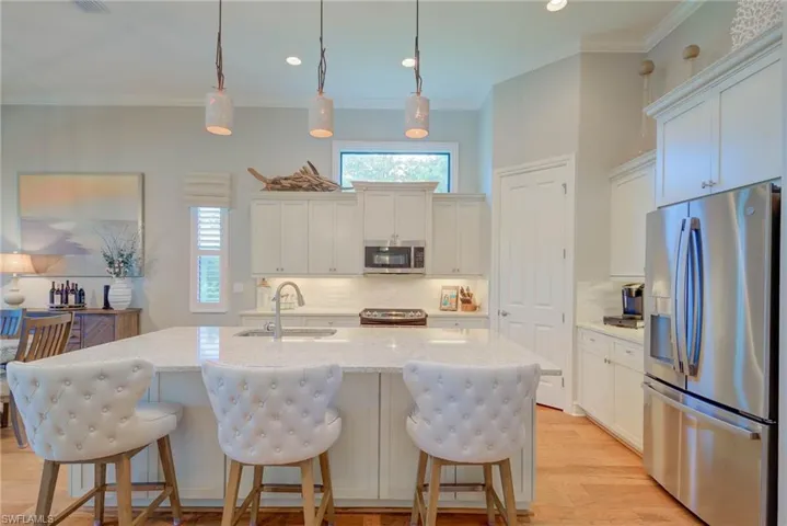 Kitchen with appliances with stainless steel finishes, backsplash, crown molding, recessed lighting, and white cabinetry