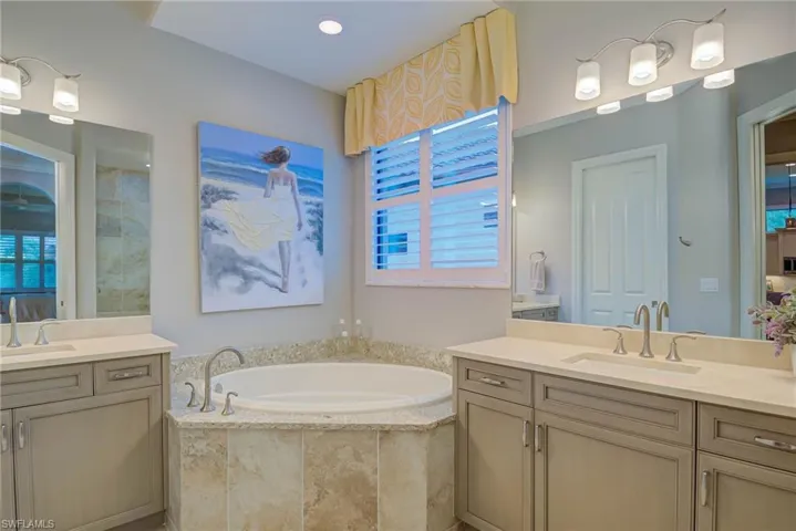 Full bathroom with two vanities and a garden tub