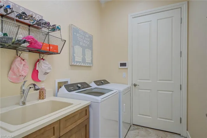 Washroom featuring independent washer and dryer and cabinet space